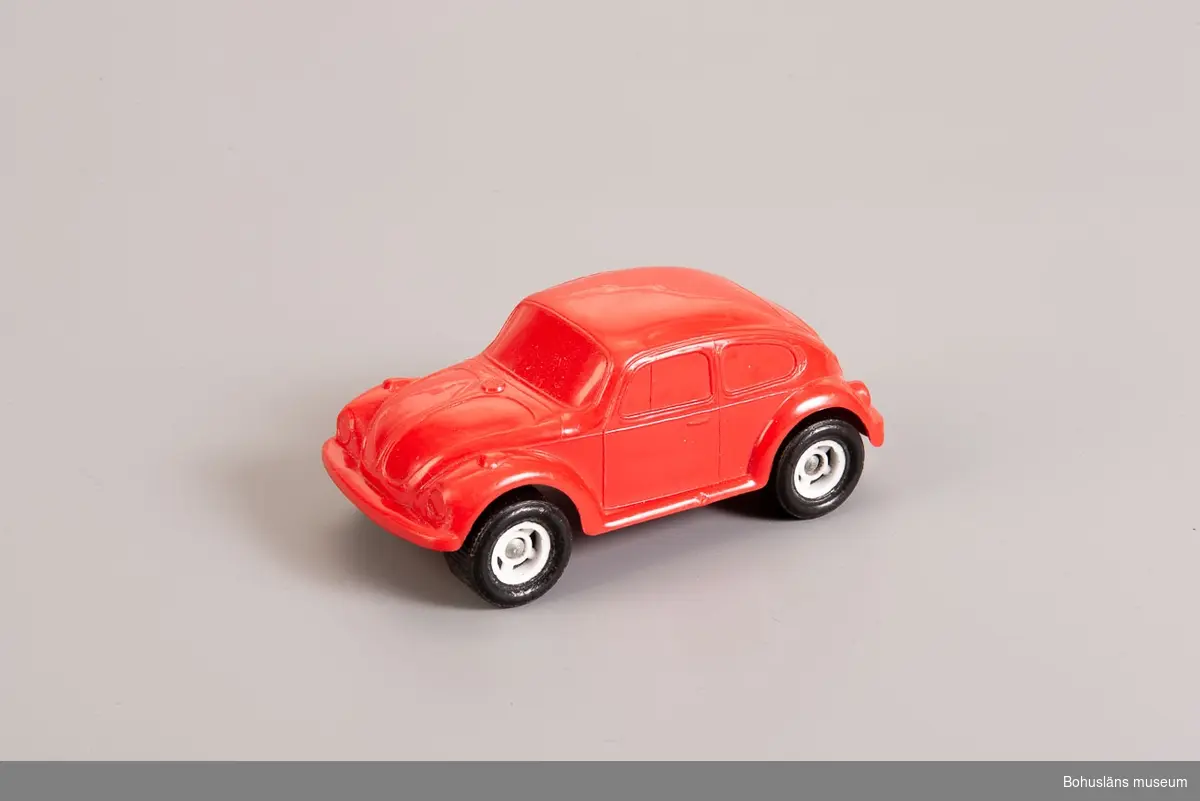 Lekaskbil i röd plast med svarta däck i modell Volkswagen.