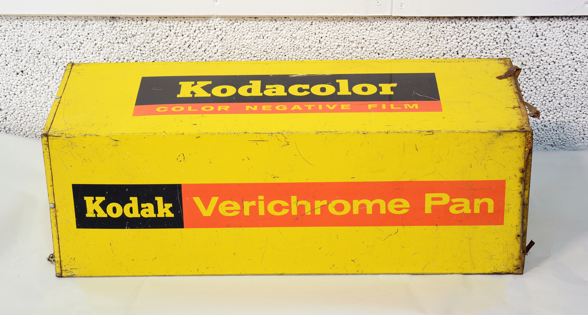 Reklame for Kodak, formet som en stor filmboks i metall med oppheng, til å henge opp på utsiden av fotobutikken.