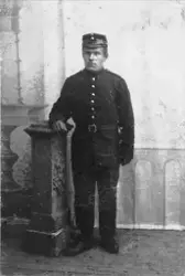 Studioportrett av en soldat, fotografert stående ved en pide