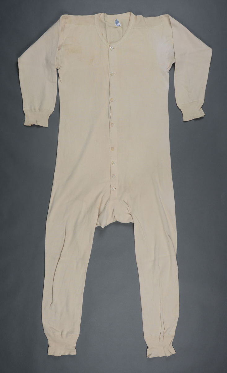 Langunderbukse og underskjorte m. lange ermer i ett: Kombinasjon m. 8 knapper i skjorten foran. Stor åpning i buksebaken med en knapp til lukking.