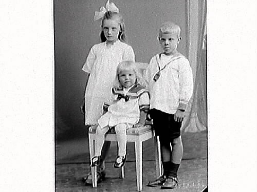 Edvin Anderssons tre barn: dottern Märta och sönerna Evert och lille Bertil som sitter på stolen. Föräldrarna är med på bildnr GB3_17513.