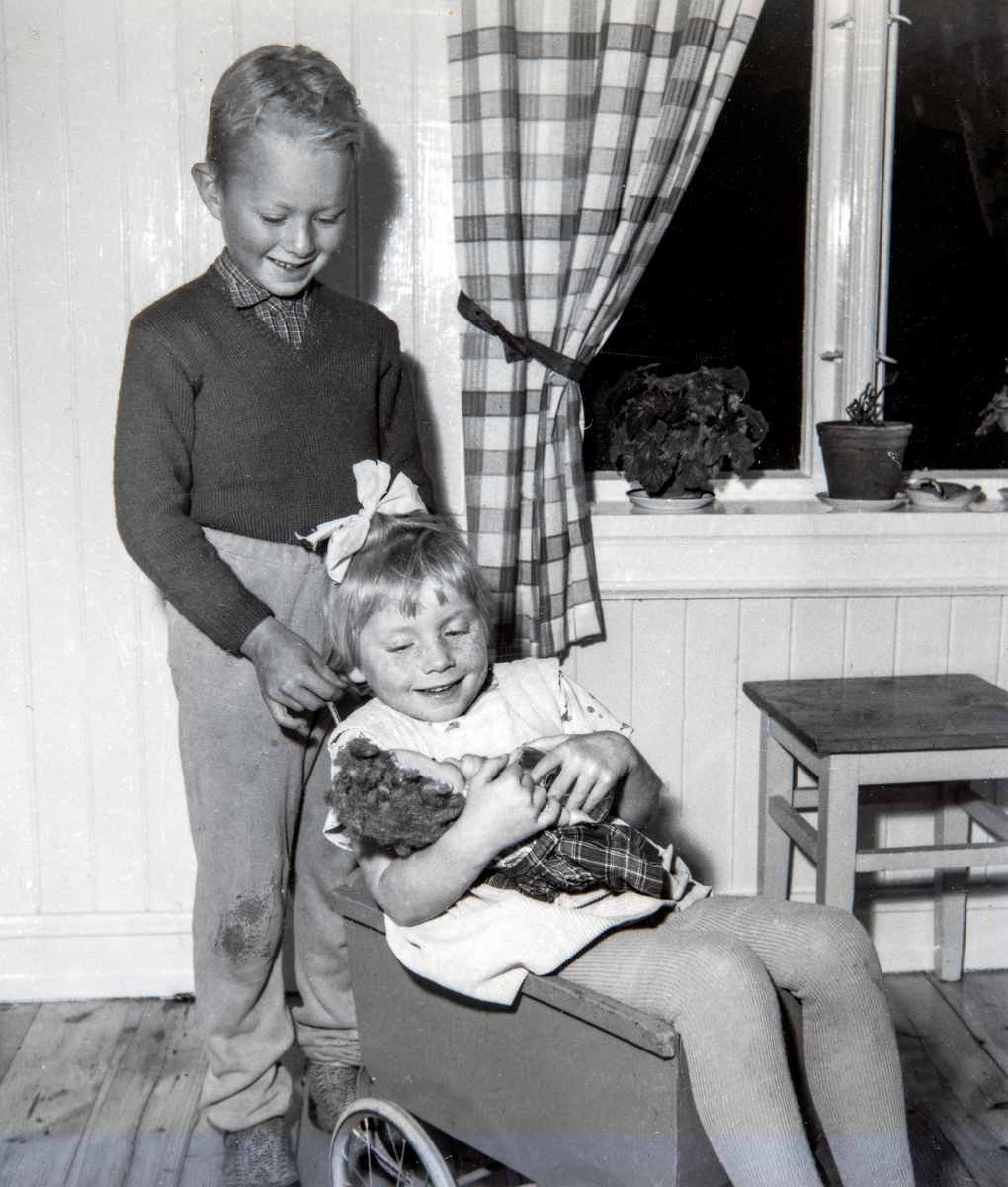 Søsken lek. Søsknene Torkel Frydenlund (f: 09.09.1951) og Eli Frydenlund ( f: 23.09.1954) i lek med dukke og dukkevogn hjemme i Vallset.