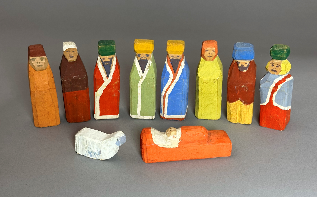 Figurer till julkrubba, målade i olika färger. 8 st människofigurer, 1 st barnet i krubban, 1 st får.