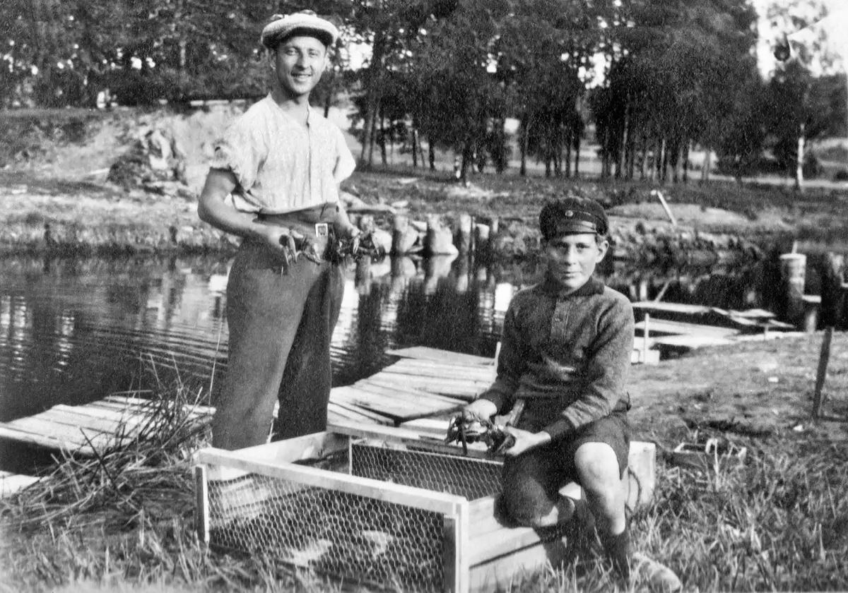 Krepsemottak ved jernbanebrua på Bjørkelangen. Harald og Kristian Dammerud med kreps i klypene. Fotograf Anders Andersson. MiA-Museene i Akershus.