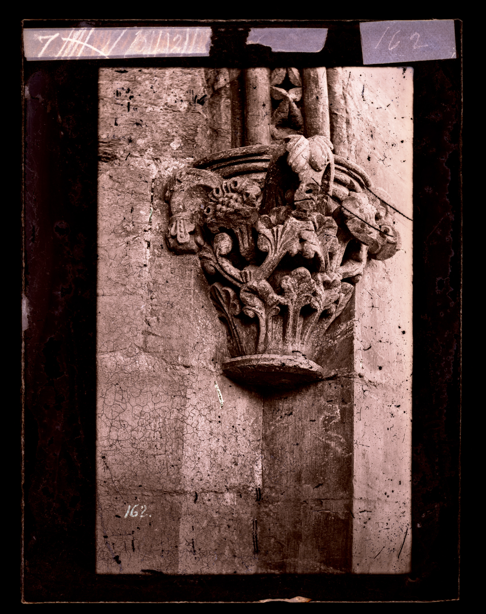 Vinduskapitel med bladverk på utsiden av oktogonen i Nidarosdomen. Bildet er tatt før restaurering, marmorsøylen mangler.