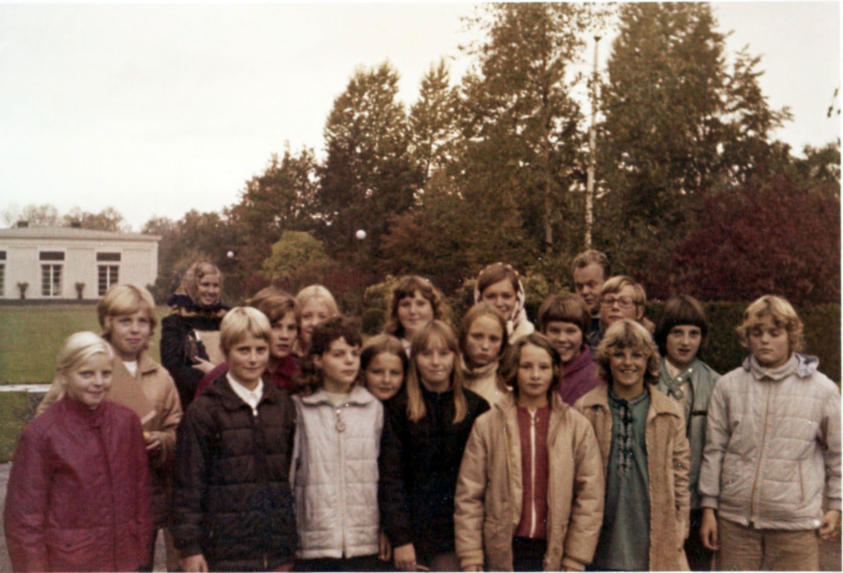 En skolklass från Brattåsskolan befinner sig på lägerskola/skolresa i Ransberg, Värmland 1980-tal. I bakgrunden skymtar del av en byggnad samt växtlighet.