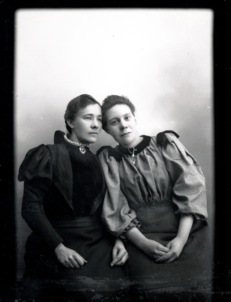 Atelierfoto. To kvinner.
Skrevet på papir som er festet til negativet: 256 søstrene Lund, se bilde GM_MG.01291_1.
