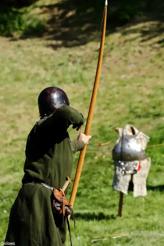 Bueskytter med langbue som skyter på en tom rustning