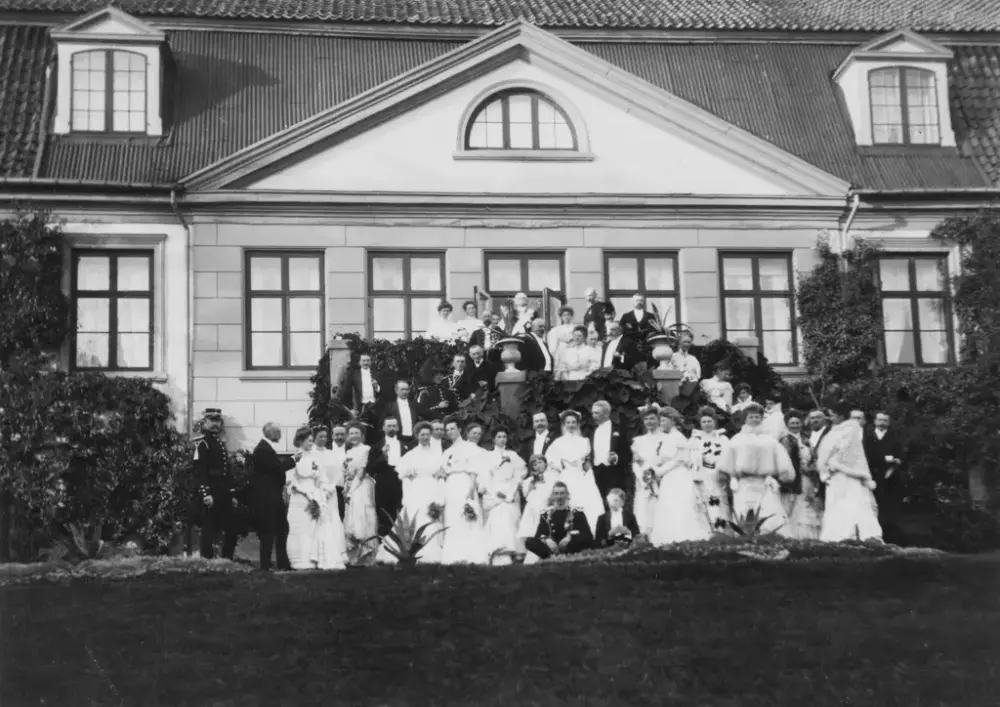 Bryllupsgjester og brudepar oppstilt på hagetrappen på Bogstad gård. 