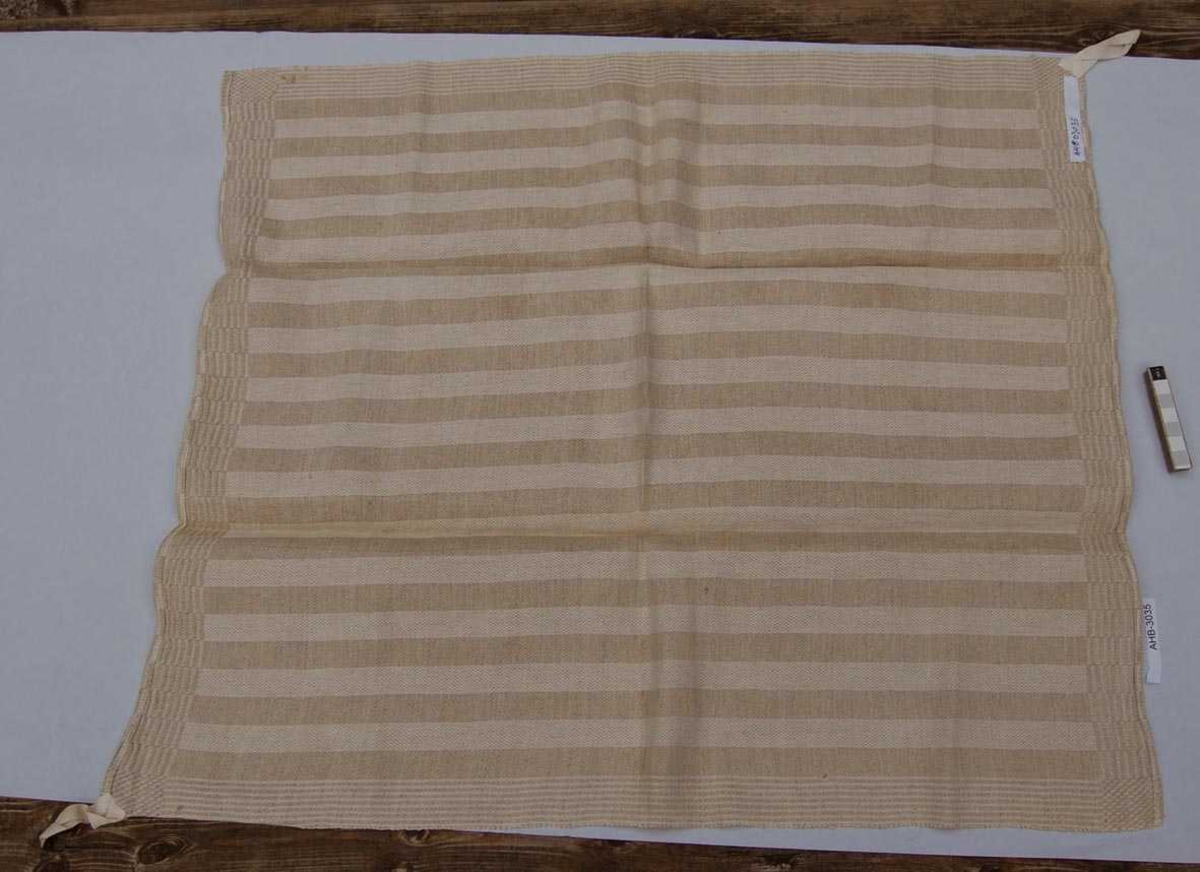 Hjemmevevd håndkle i tofarget lin. Stripemønster med kanter i annet mønster.