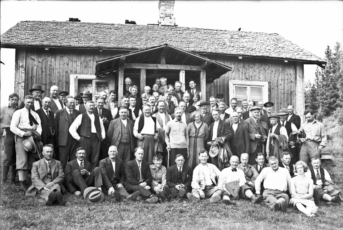 Forsamling - mest menn. På bildet: Bestyrer Sigurd Storm i Eidsvoll Almenning, Hans O Habberstad, Otto Halberg, Ole Sandholt. Fra tidlig 1930-tall. Kan være på Jøndalsvangen.
