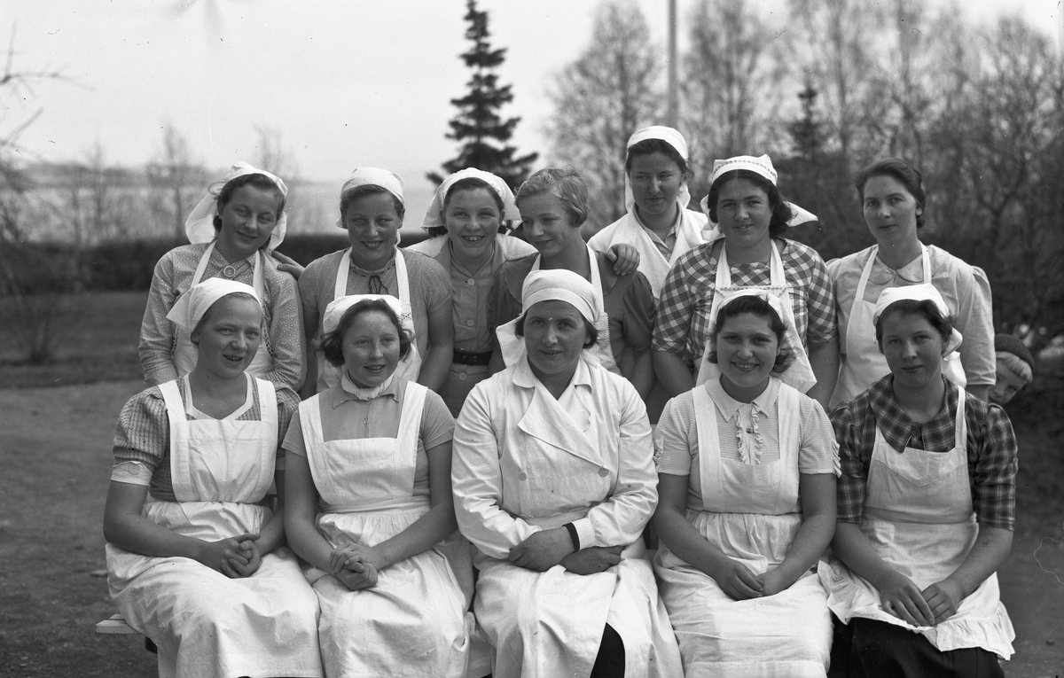 Gruppe kvinner i hvite uniformer. Kan være fra Landbruksskolen på Toten.
