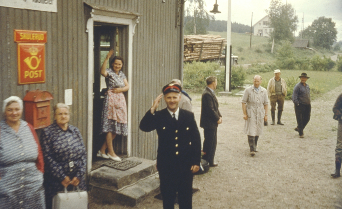 Stasjonsbetjent og lokalbefolkning vinker farvel til siste ordinære tog fra Skulerud.