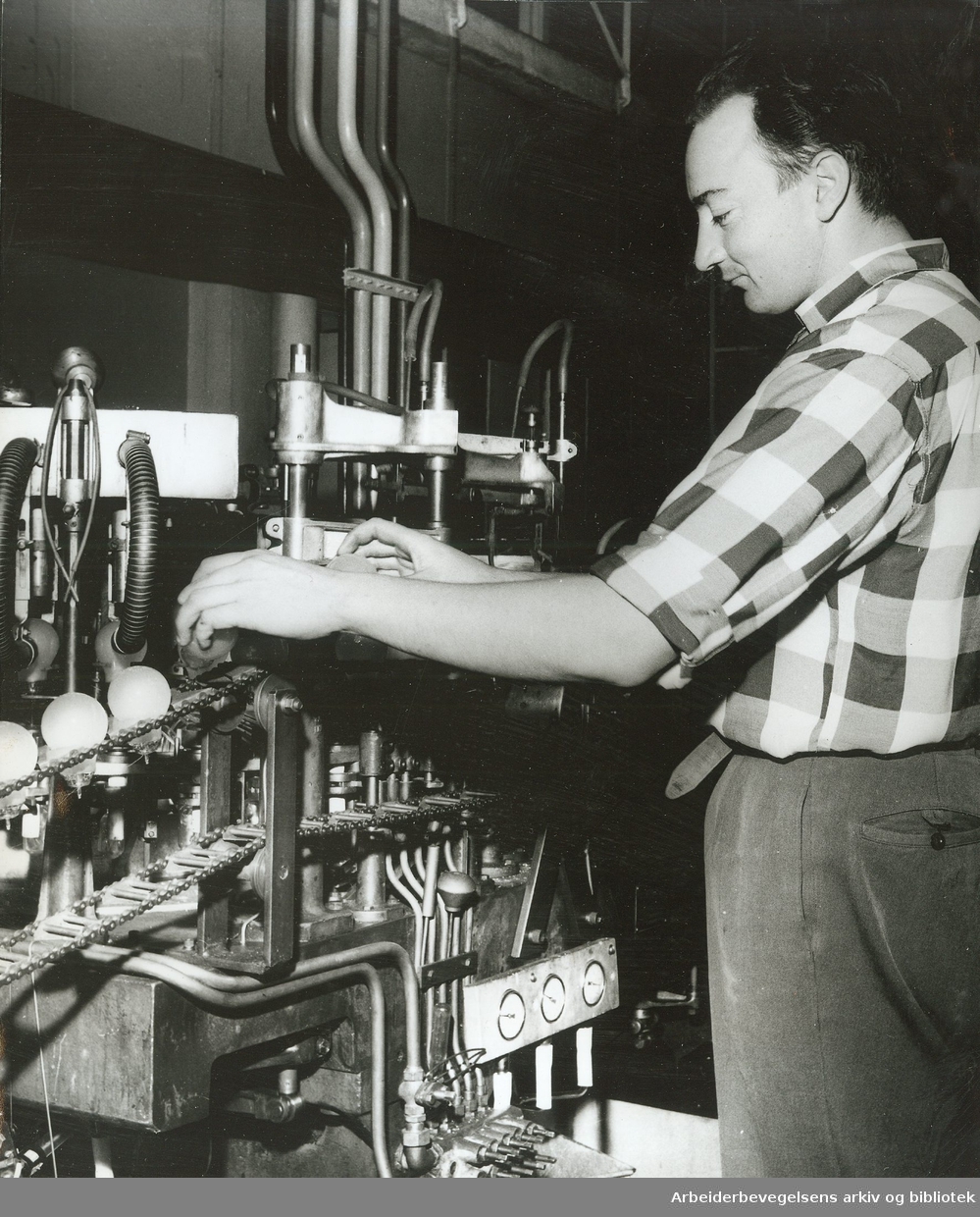 Lyspæreproduksjon ved Luma Fabrikker,.Egil Nordhagen kontrollerer avsmeltingen i pumpeautomaten,.ca. 1960