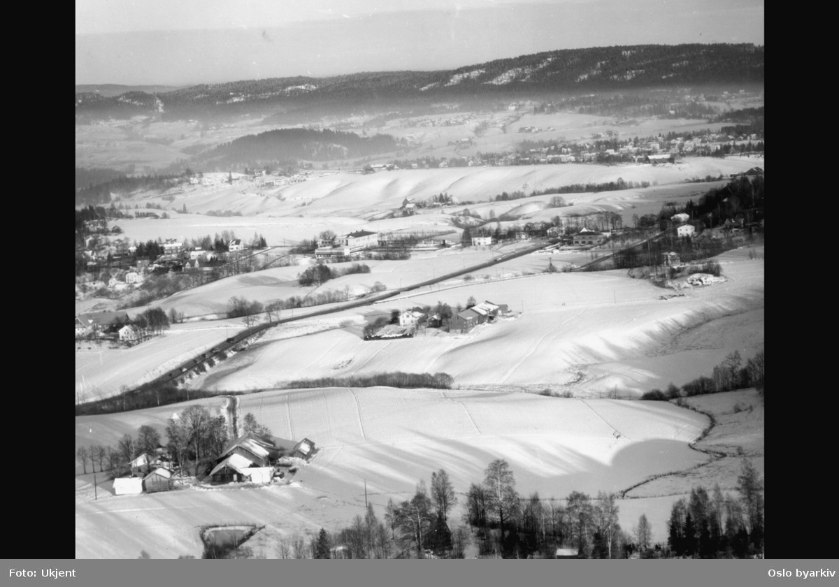 Jordbruksområde, villabebyggelse, snø (Flyfoto). Bildetittelen er noe misvisende, Furuset skole er midt i bildet, med Lindeberggårdene og Strømsveien på skrå over jordene.