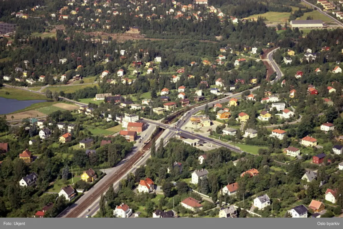 Sørkedalsveien og Ringveien møttes i Smestadkrysset. Trikkesporet til Røabanen/kolsåsbanen følger Sørkedalsveien . Smestaddammen til venstre. (Flyfoto)