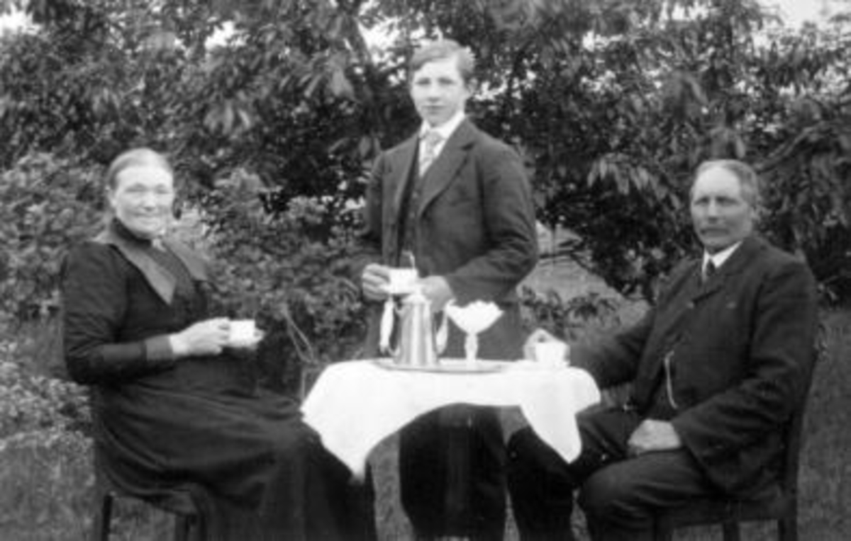 3 personer ved kaffebord ute. Fra venstre er Anne Louise Larsdatter Ekeberg (1864-1934), Lars Olsen Ekeberg f.1897, Johan Larsen Ekeberg (1859-1918).