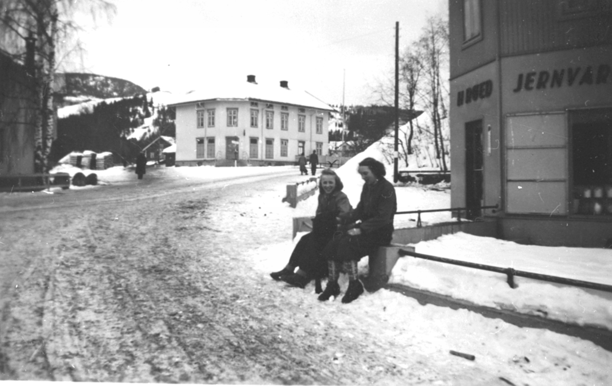 Furnesvegen, Brumunddal. H. Røed jernvareforretning, Finsdal, Kolloen landhandel. 2 damer i forgrunnen.