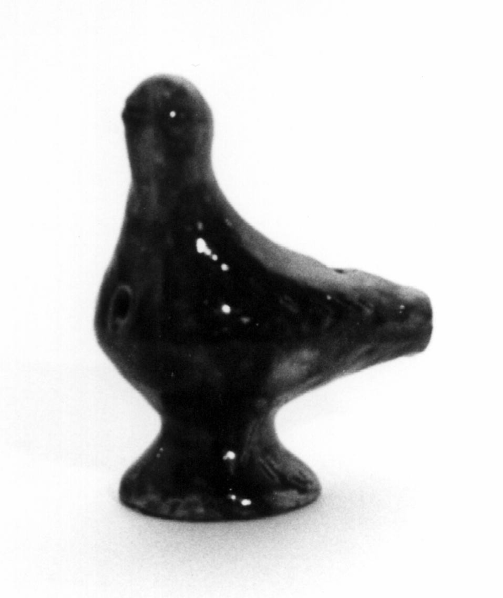 Spaltefløyte i keramikk i form av en fugl, utvendig med brun glasur.
Spalte og labium i stjerten, ett fingerhull i brystet.

