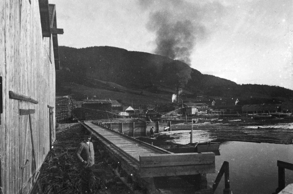 Fra Strandheim Brug og Orkedalsøren ca. 1873-1875. Marentius Thams (1836-1907) står i forgrunnen. Trelasttomter og dampsagbruk.