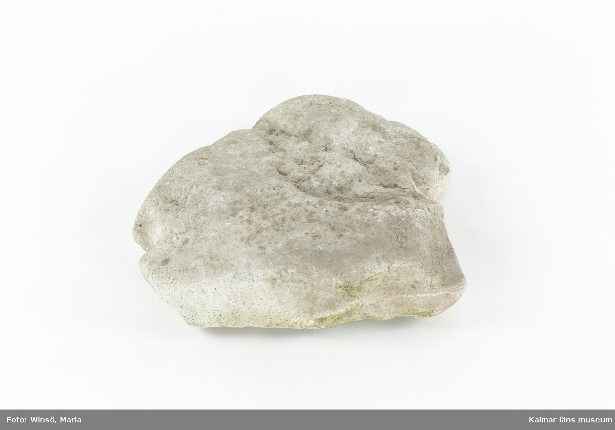 KLM 12566:1-2. Ankare. Naturvuxen stam av ene (:1) med klykor för fastsättning av en sten (:2) som tyngd. Enestammen är i ena änden tillsnidad för fastsättning av rep. En av klykorna som håller stenen på plats har gått av och saknas, en av de andra klykorna är avbruten men bevarad. Stenen är naturligt formad med två urhuggningar på vardera sida. Enligt museets äldre register är ankaret av en "sällsynt och primitiv typ".