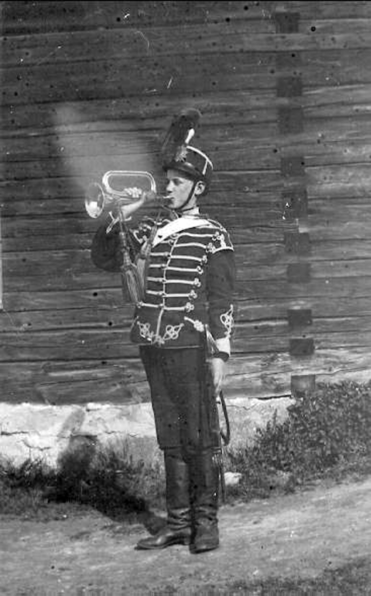 Ung trumpetare I K 3 m/ä. Pojken tillhör musikkåren vilket framgår av "svalboet" på vänster axel och röd plym i mössan. Kortet taget i Hallsberg.