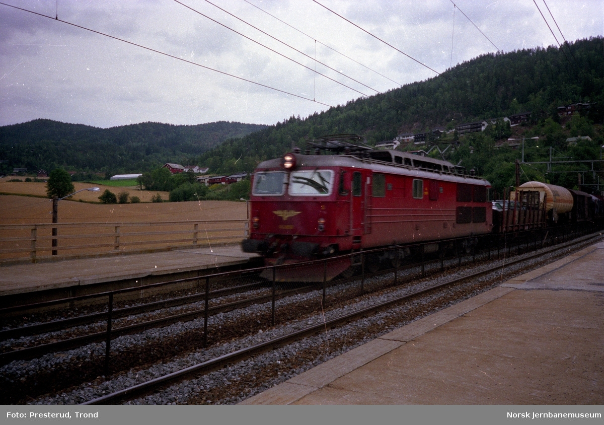 Elektrisk lokomotiv type El 14 med godstog passerer Lier (Tuverud) holdeplass