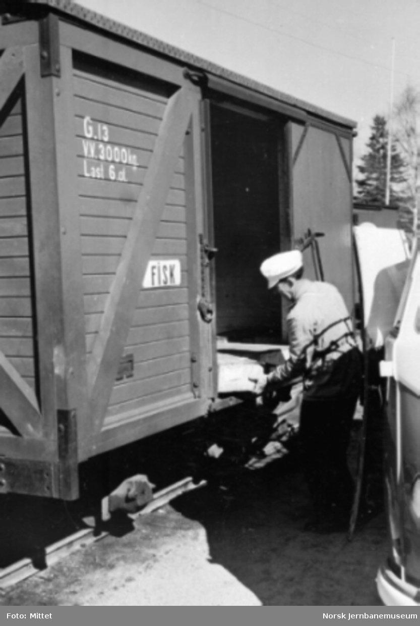 En mann laster ut gods fra godsvogn litra G nr. 13 på en av Aurskog - Hølandbanens stasjoner