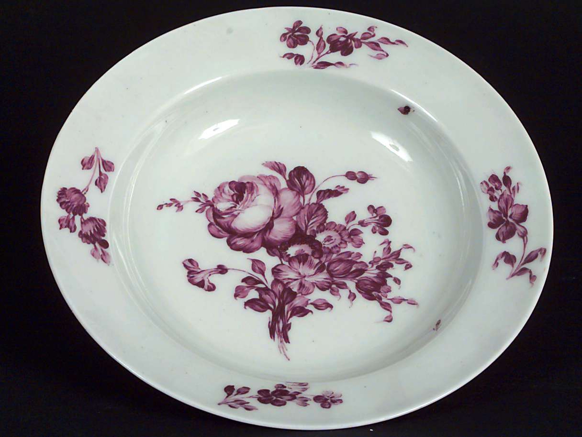 Desserttallerken, dyp i porselen. Hvit med rosa blomstermotiv i bunn og på kanten.