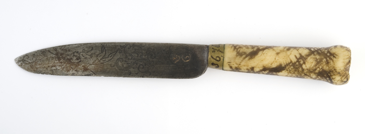 Kniv med skaft av marmorert ben. Planteornamenter, engel, kronet monogram, datering 1760 og innskrift på knivblad. 

Kniven hører sammen med gaffel NM.036769 - ikke revidert.