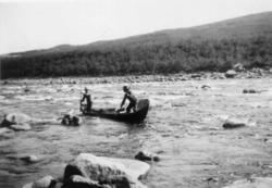 To personer staker en båt i et stryk i Tanaelven 1933.