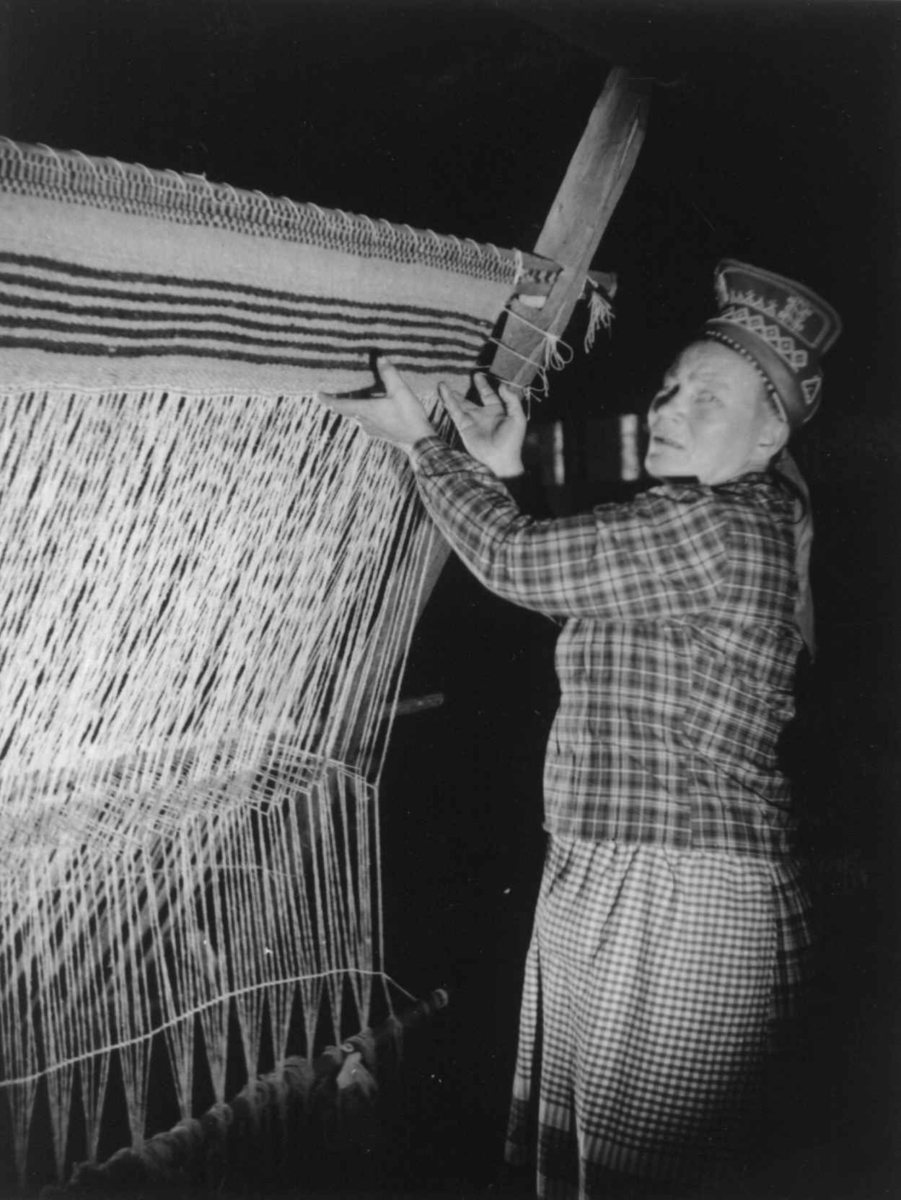 Greneveving (34). Skoltesamene Darja Jefreimov vever greneteppe. Seurasaari 1955.