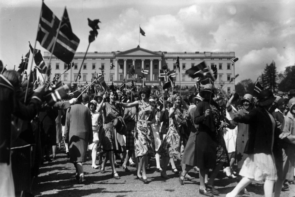 17. mai-tog på vei ned fra Slottet. 1924. Kvinner med flagg. Slottet i bakgrunnen.