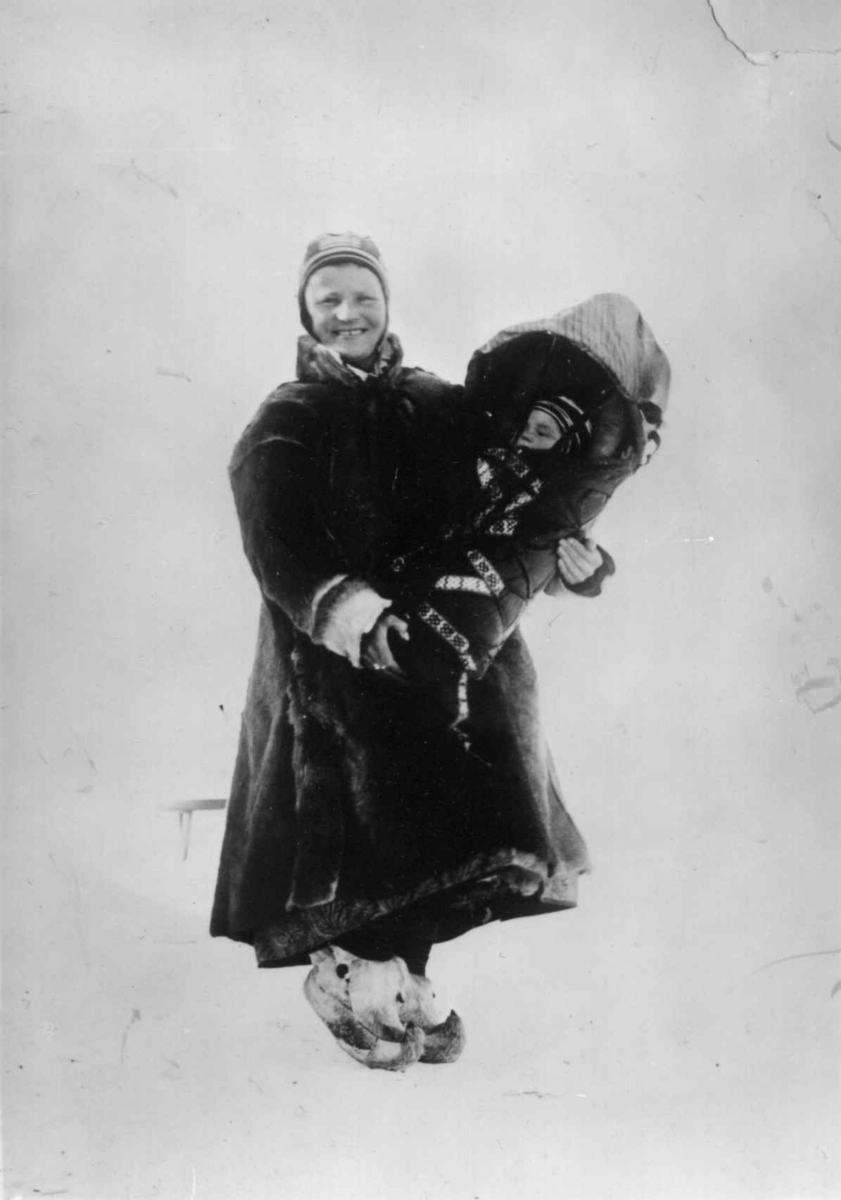 Kvinne med barn i komse, Sør-Varanger, Finnmark, før 1900. Antatt å være Marit Banne med datteren Inga.