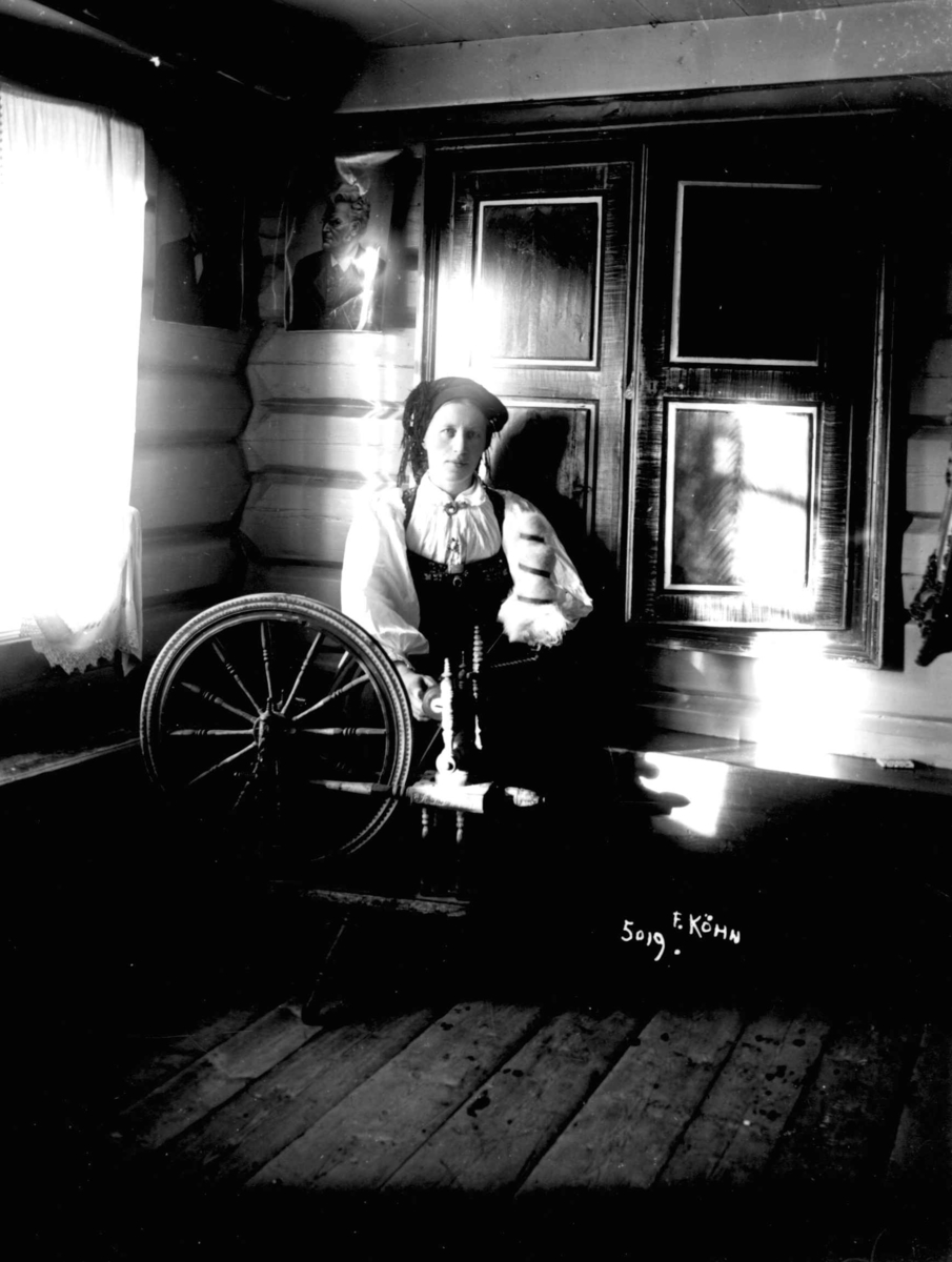 En kvinne spinner på rokk, antagelig 1910. Setesdal, Aust-Agder.