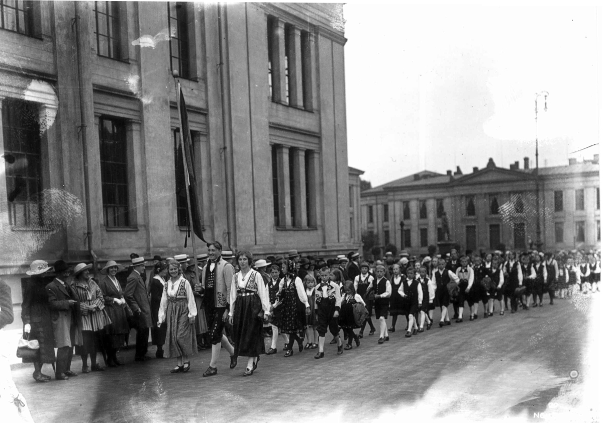 Nordisk Folkedansstevne ant. Karl Johans gate ved Universitetet - Oslo. 1925. Opptog av norske 
folkedansere.