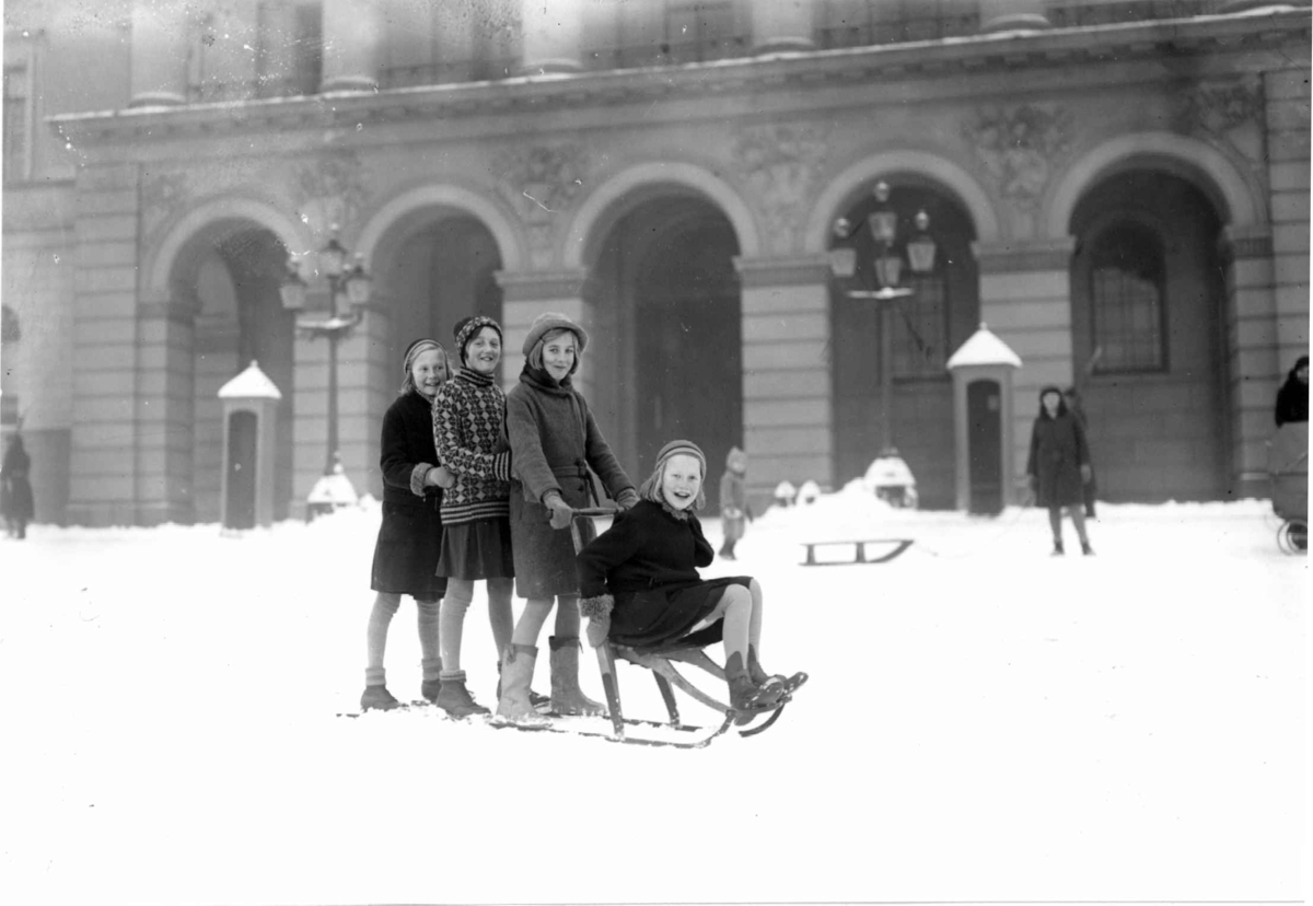 Oslo. På spark.  Vintermotiv. 1930-1931. Piker på spark foran Slottet. Vakter i bakgrunnen.