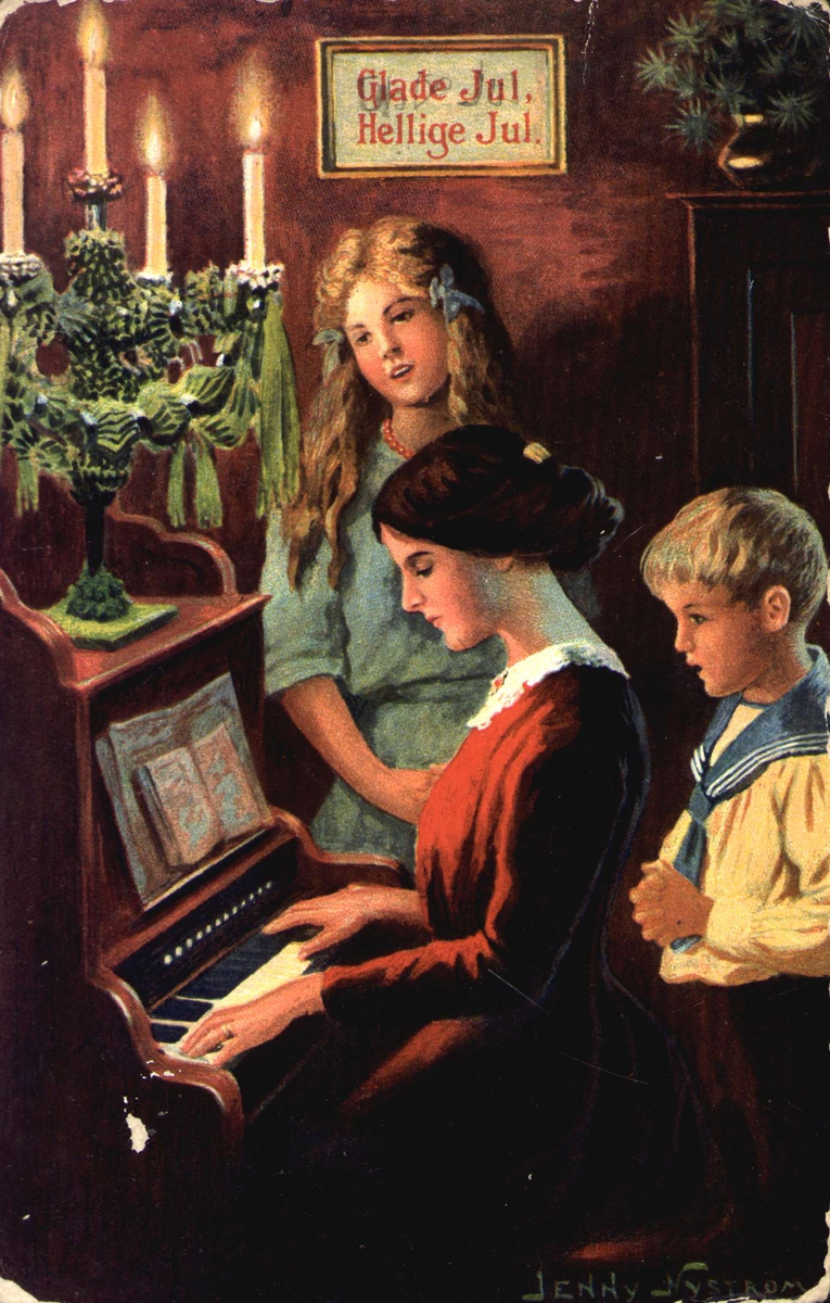 Julekort. Jule- og nyttårshilsen. Mor sitter ved pianoet. To barn står ved siden av henne. Tekst: "Glade Jul, Hellige Jul". Illustrert av Jenny Nyström.