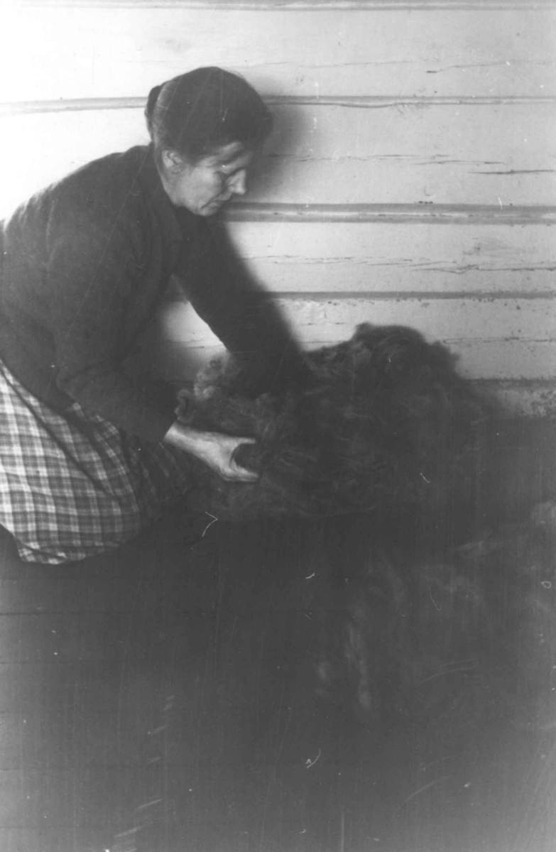 "Plukka ull". Gunnhild Smeland sitter med ull som er kardet en gang. Åseral, Vest-Agder 1943. 