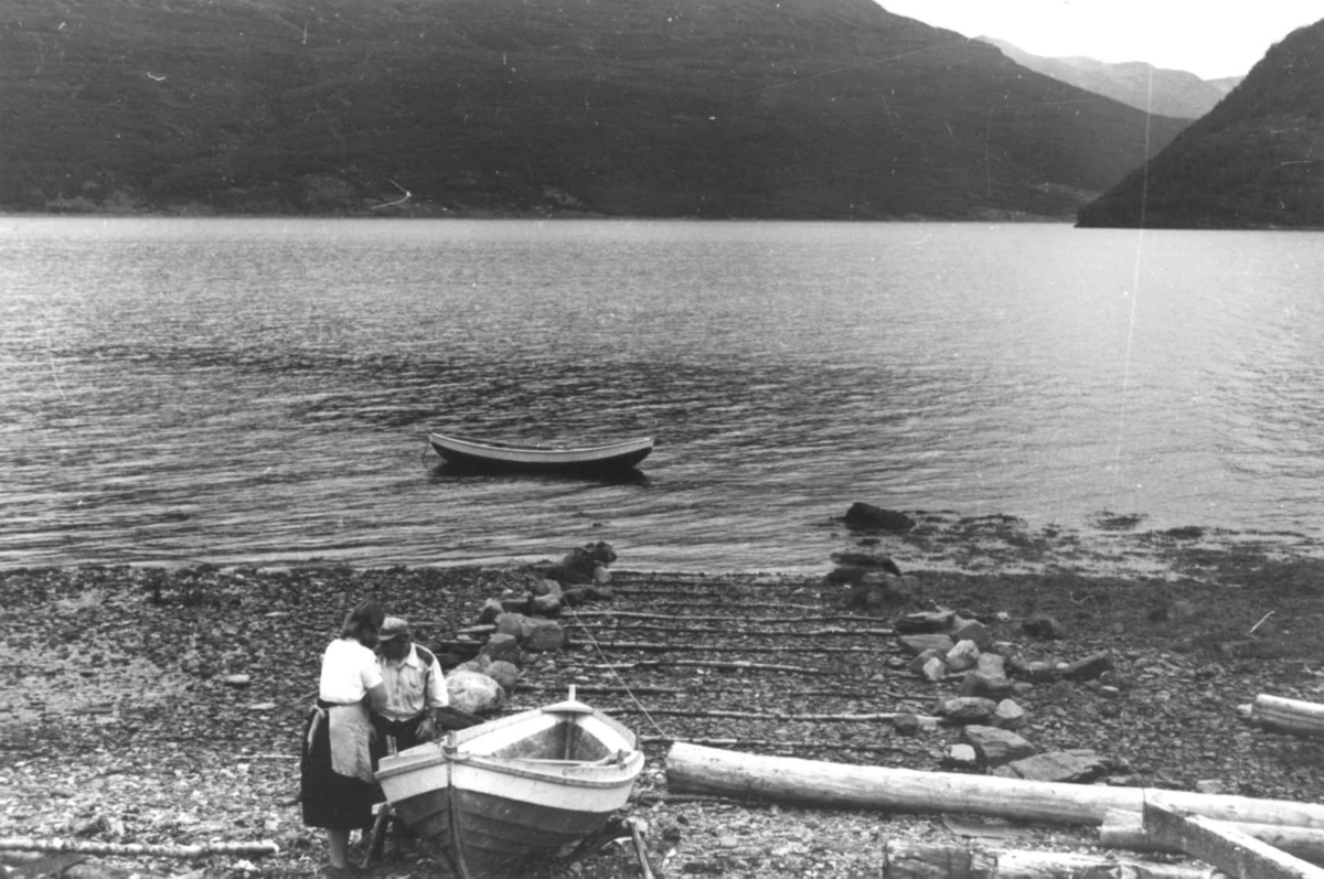 Båtstø. To personer har dratt en båt på land. Olderdalen, Kåfjord, Troms 1947. 