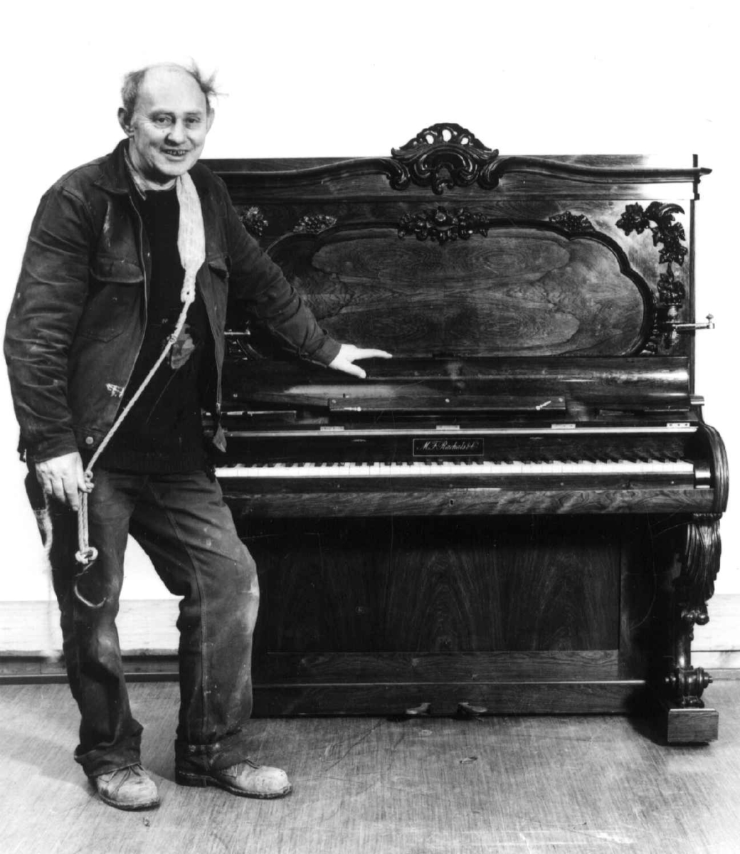 Kjell Martin Haugan, smed på Norsk Folkemuseum, skal flytte et piano, og står klar med bærestropp over skuldern en gang høsten 1985.