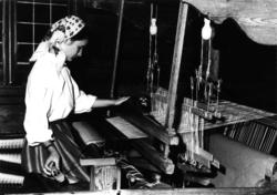 Trude Haaland ved vevstolen i Smestadstua, 1986. Hun vever f