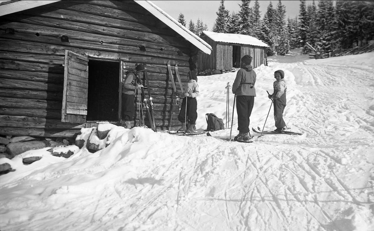 Vintermotiv. Skiløpere utenfor fjøset på Ligardshaug i 1942.