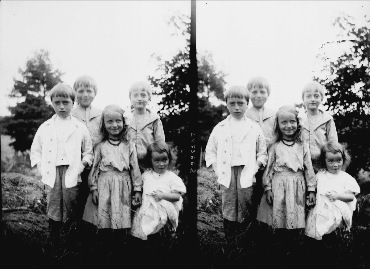 Fem barn oppstilt utendørs for fotografering, muligens noen av barna i familen Q. Wiborg.