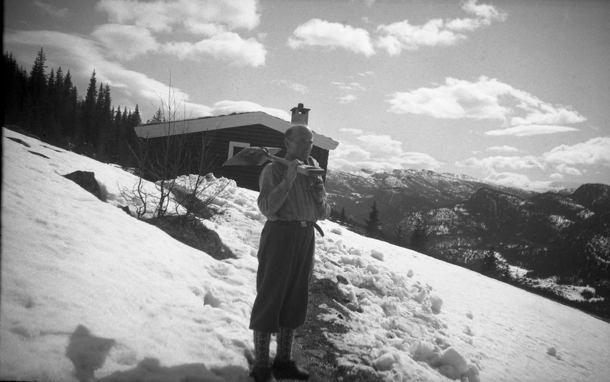 Fritjof Arentz måker snø foran feriestedet Ligardshaugen i Eggedal. Fotografert påsken 1949.