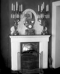 Kamin med skulpturlysestaker og lys. Murmester Paul Kristens