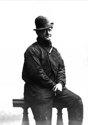 Portrett, mann i arbeidstøy i studio. Sigarett i handa. Feie