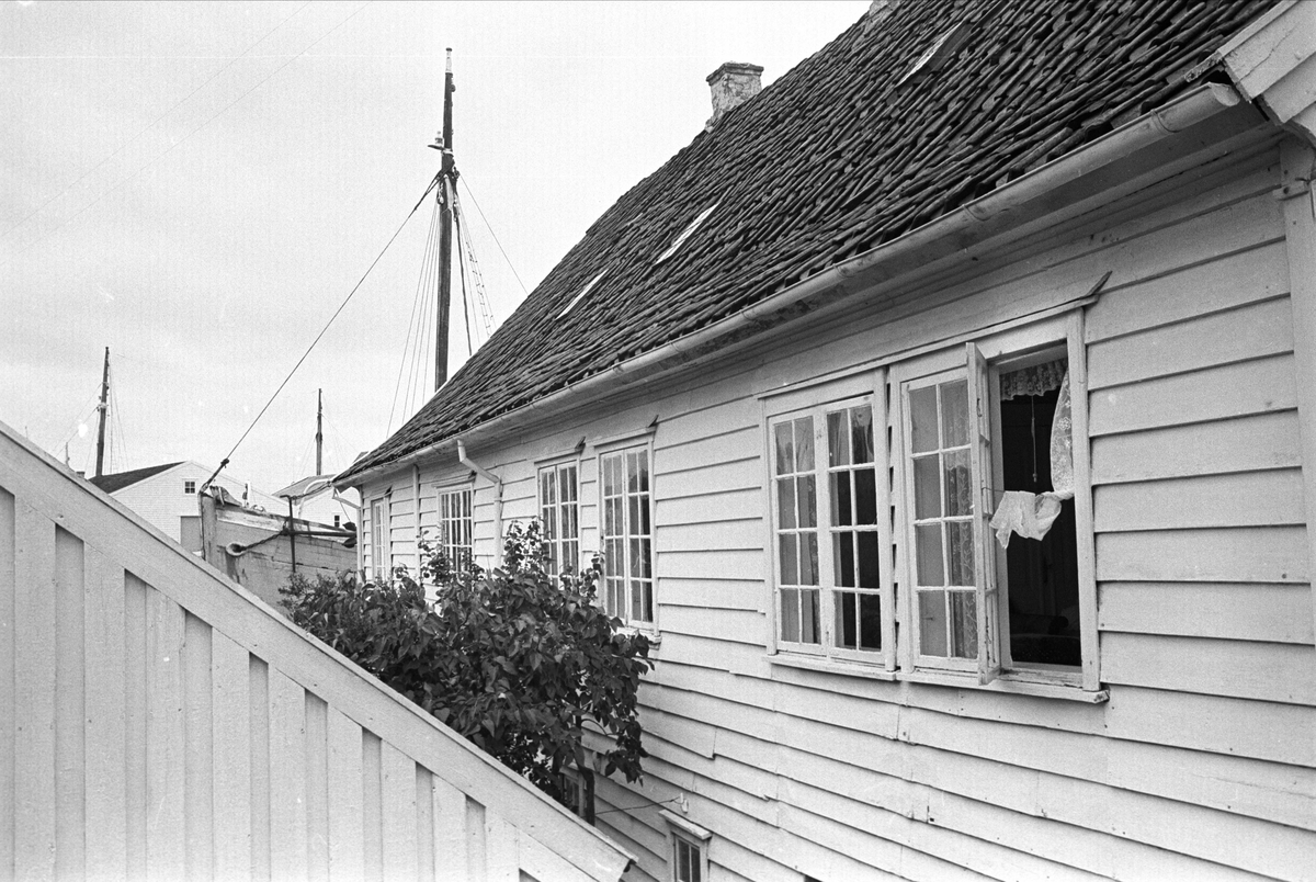 Fra Karmøy august 1965. Hus med båt i bakgrunnen i Skudeneshavn.