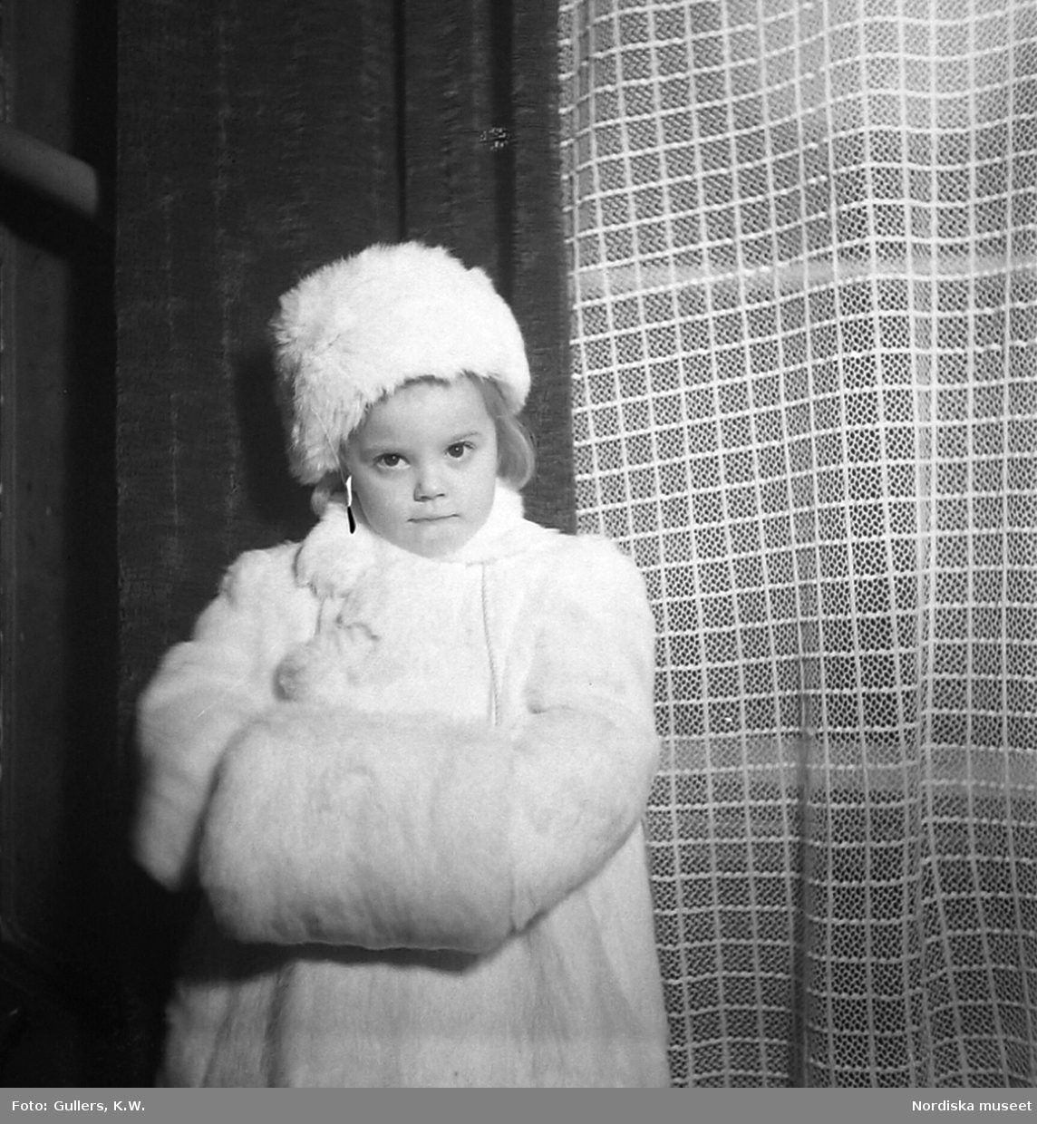 Flicka i vit päls. Julfirande hos familjen Lidén 1943.