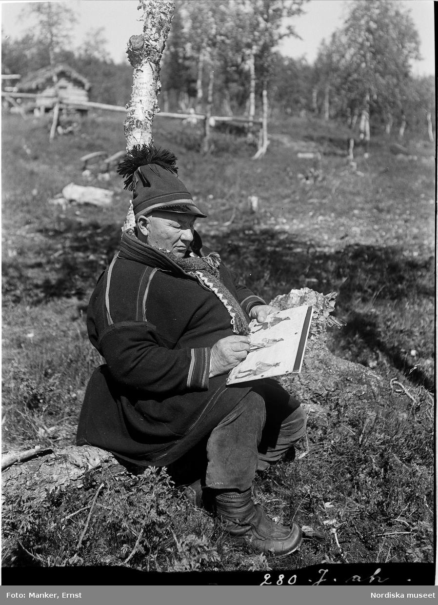 Nils Nilsson Skum, renägare, nomad, tecknare. 65 år (f.1872) Sjiskavare, Norrkaitums sameby. Här med block och penna i handen.